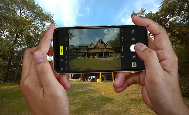 taking photo of a log house with smartphone camera